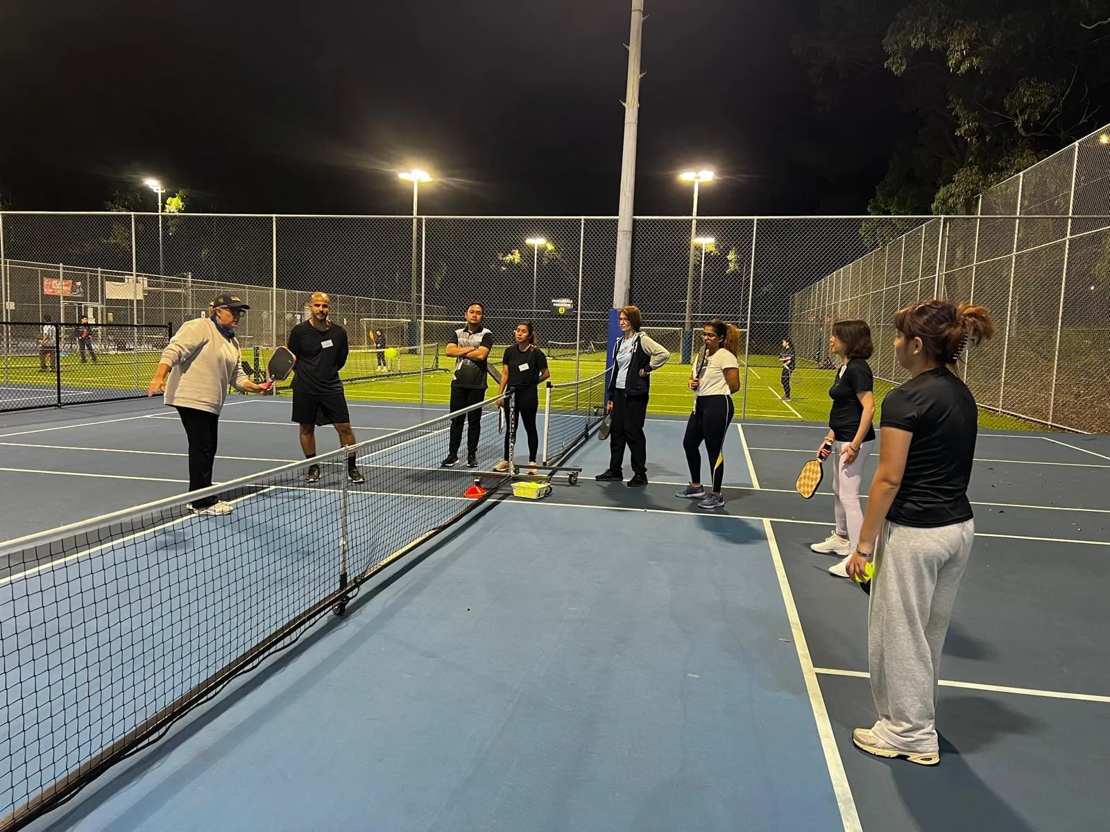 A Play Pickle coach running a clinic with players on court