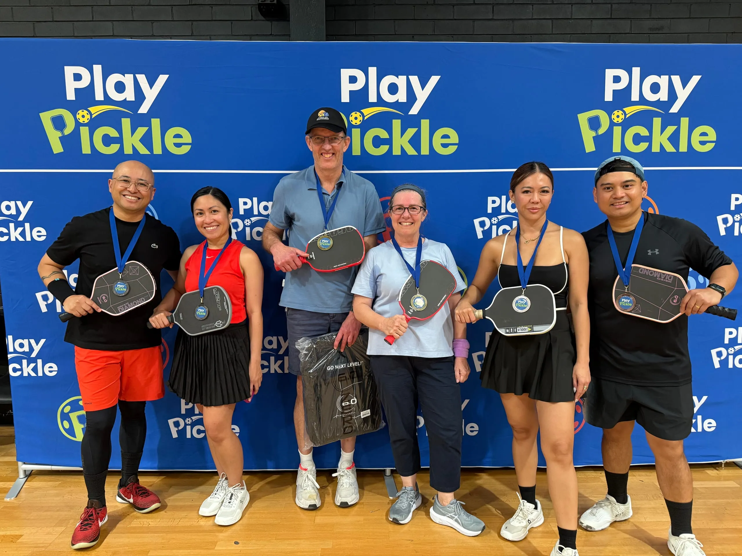 Play Pickle league winners celebrating with medals and paddles