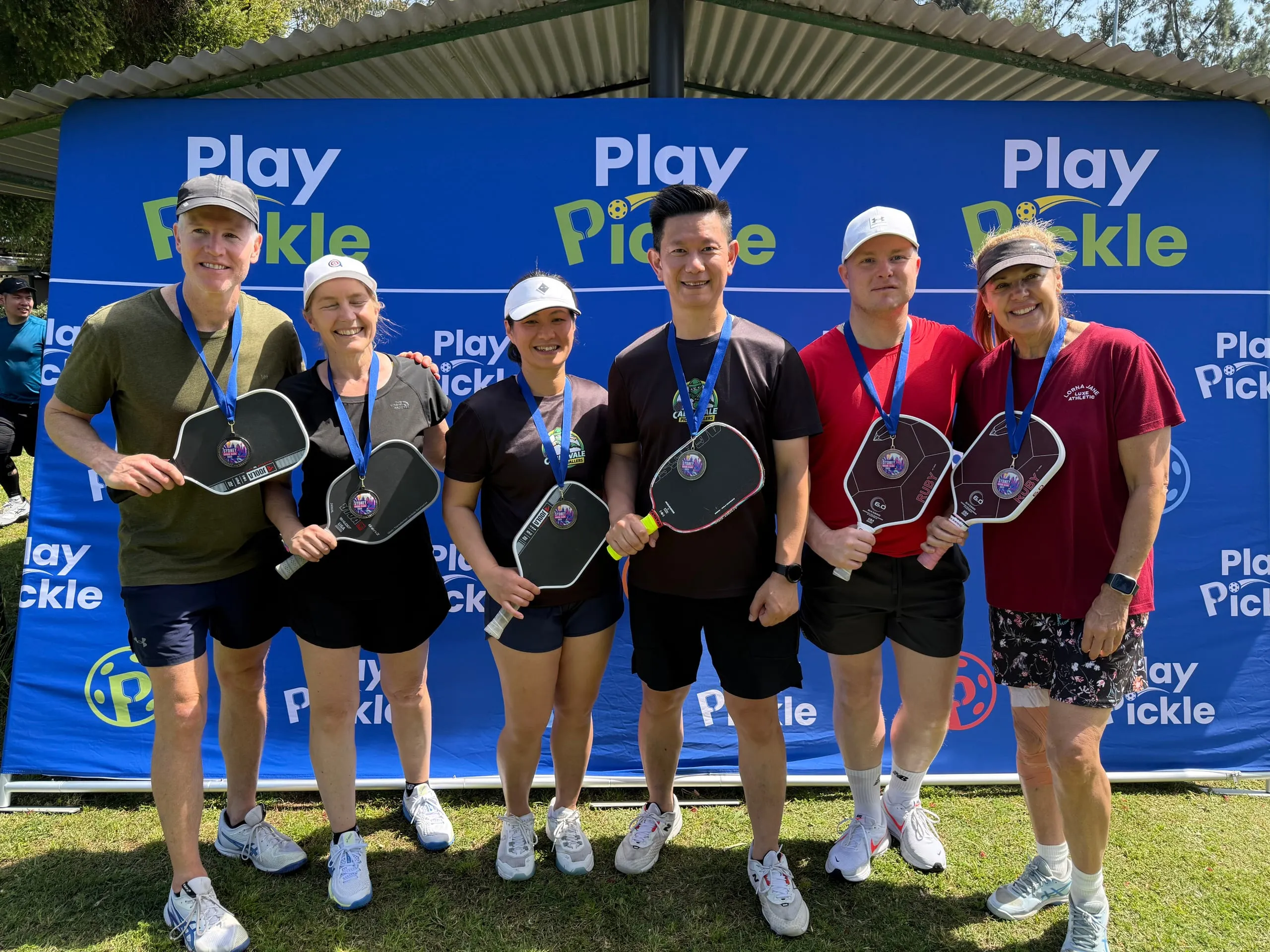 Six Play Pickle players with medals after a league finals match